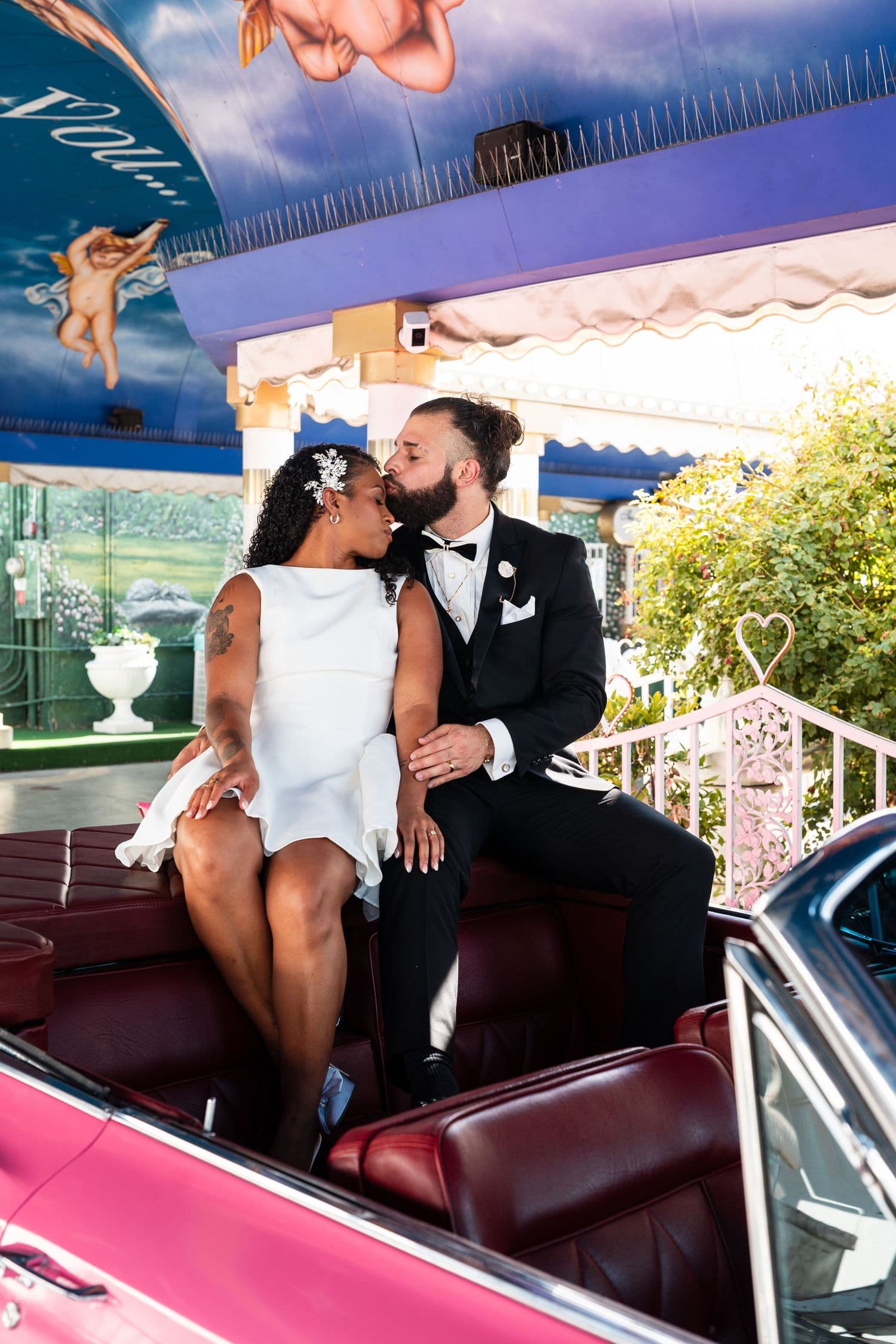 Couple in the backseat of the pink classic car