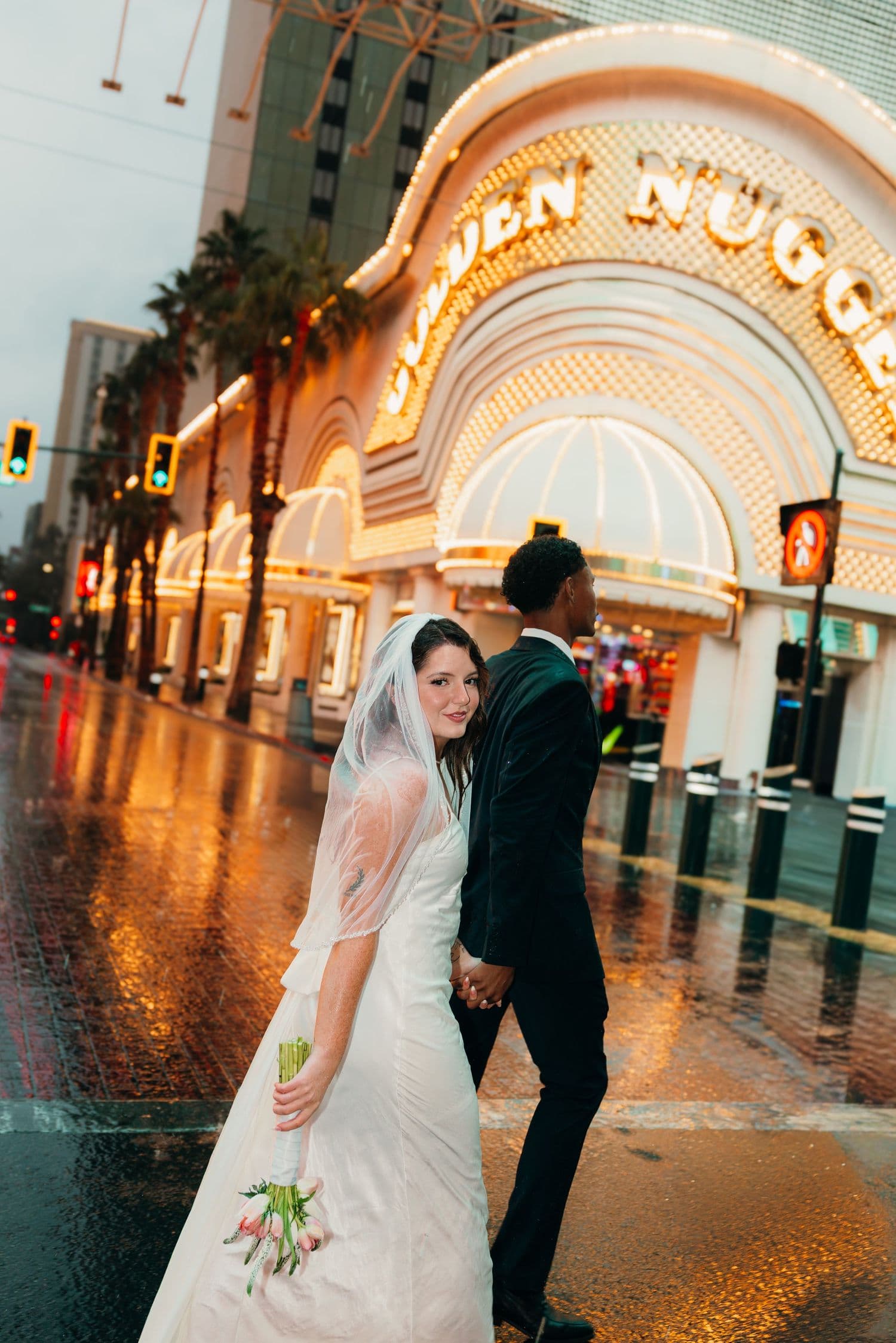 A couple holding hands outside the Golden Nugget on a rainy evening