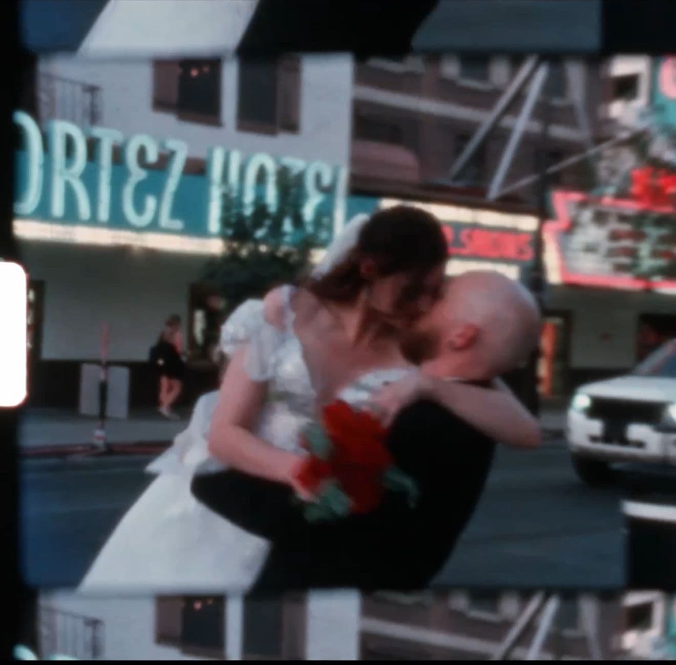 A romantic dip pose outside a vintage neon-lit diner
